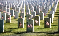 ARLINGTON, VA - MAY 24:  Small US flags wave in the wind after being placed in front of headstones at Arlington National Cemetery during the Flag-In Ceremony ahead of the Memorial Day weekend May 24, 2007 in Arlington, Virginia. It took approximately 3 hours for 1,300 soldiers, sailors and marines to put more than 300,000 flags in front of each of the gravestones at Arlington National Cemetery.  (Photo by Chip Somodevilla/Getty Images)